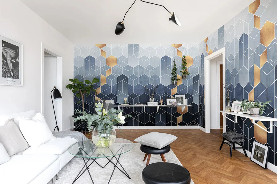 Living room with a sofa, a transparent glass coffee table and tv console, with geometric blue & gold wallpaper